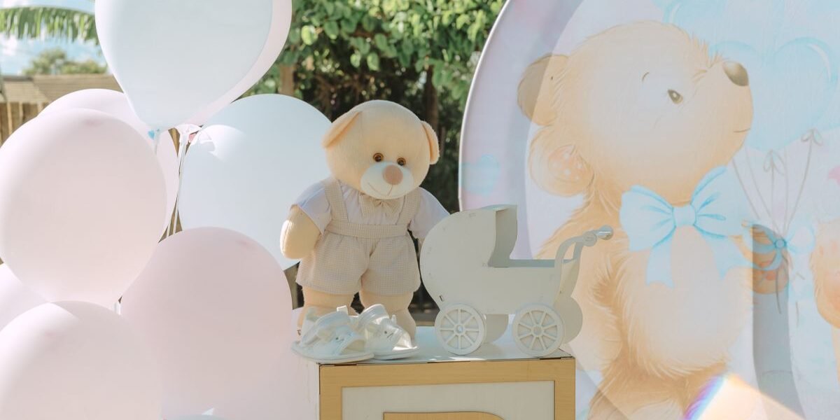 Babyshower decoratie met ballonnen en teddybeer bij een babyshower uitnodiging