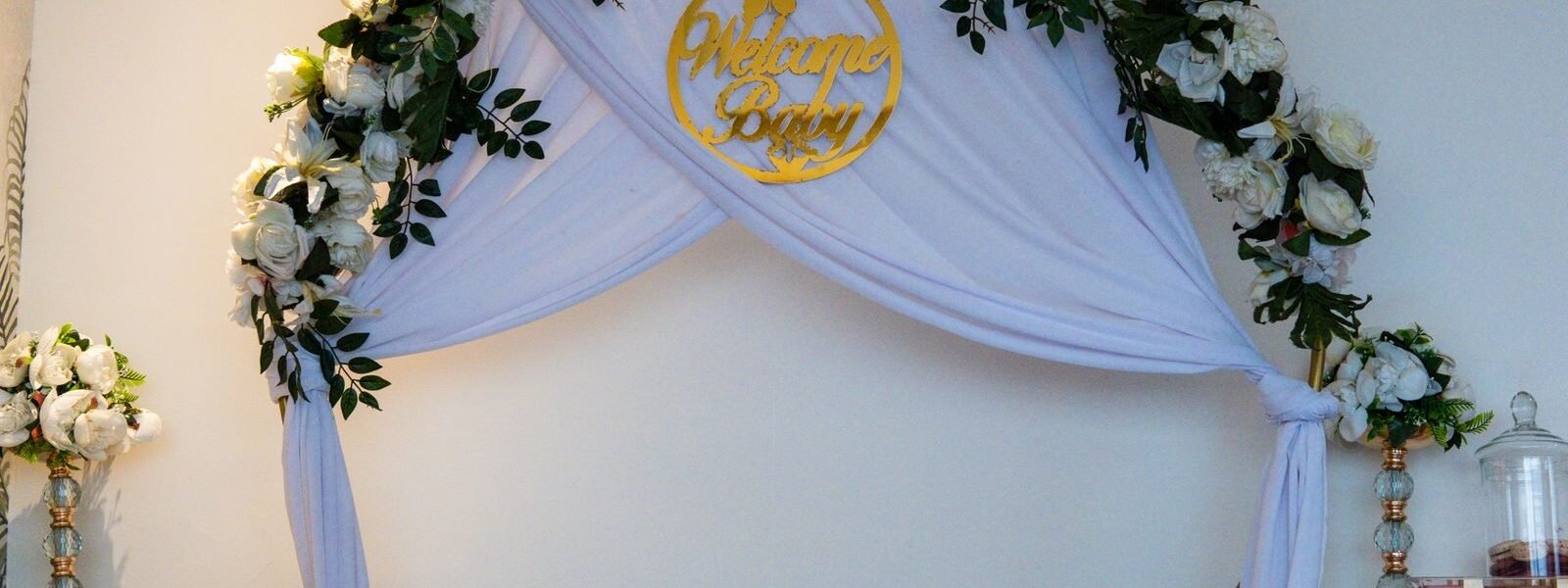 babyshower versiering met bloemenboog en welkomstbord