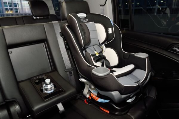 Baby in autostoel groep 0+ die op een kinderwagenonderstel wordt geklikt