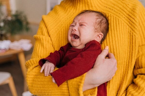 Huilende baby wordt getroost in de armen van een ouder