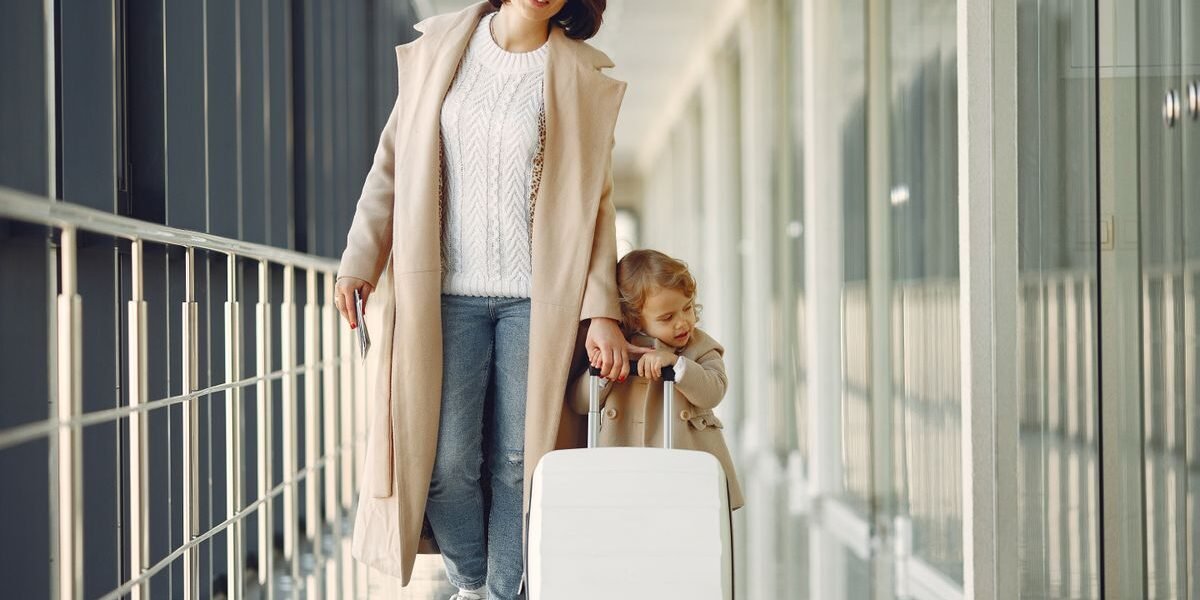 Ingeklapte compacte buggy als handbagage naast een koffer in de luchthaven