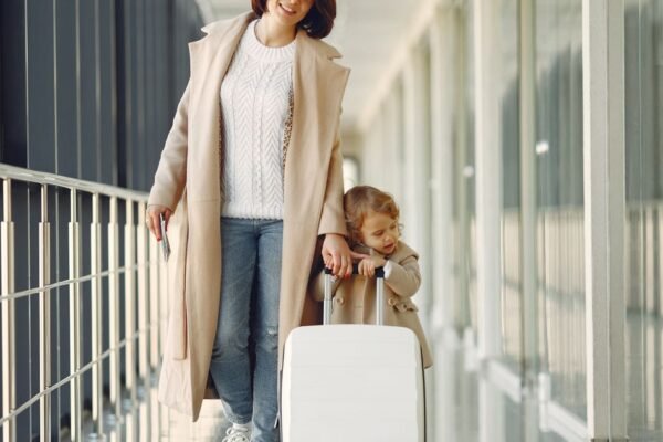 Ingeklapte compacte buggy als handbagage naast een koffer in de luchthaven