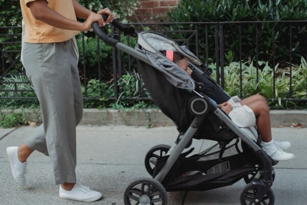 Lichte buggy opgevouwen gedragen met een kind op de arm in de stad