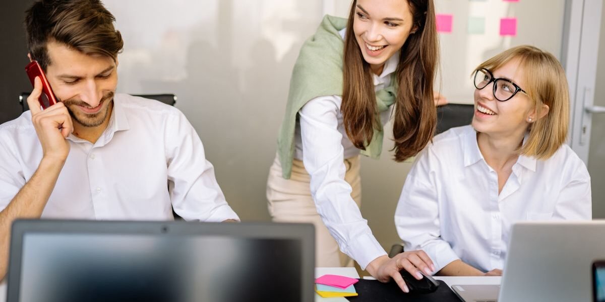 Collega's bekijken samen een geboortelijst op een laptop op kantoor