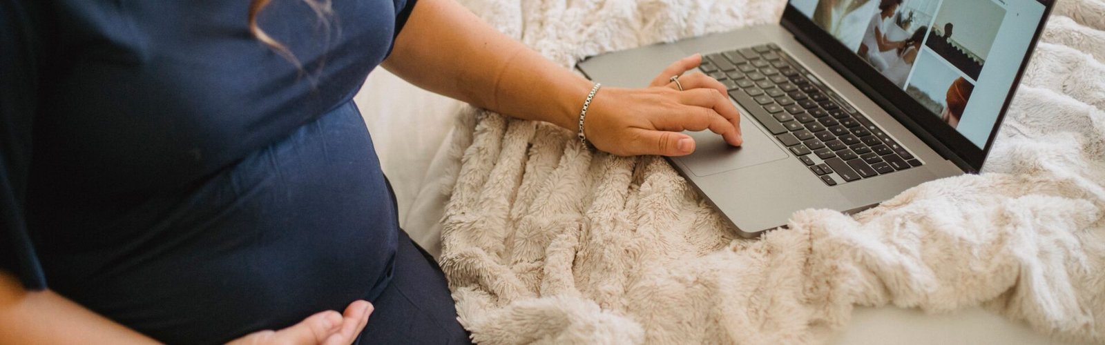 Ouders stellen op een laptop een geboortelijst samen uit verschillende webshops
