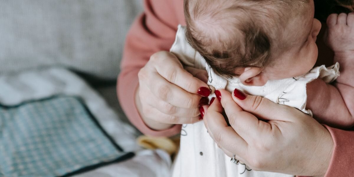 Pasgeboren baby in rompertje en mutsje klaar om naar huis te gaan