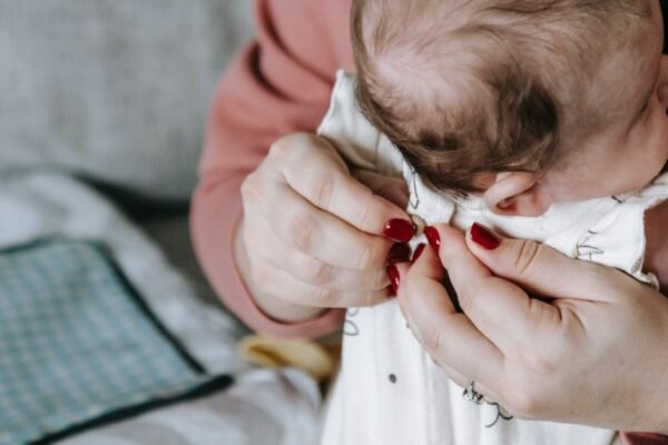 Pasgeboren baby in rompertje en mutsje klaar om naar huis te gaan