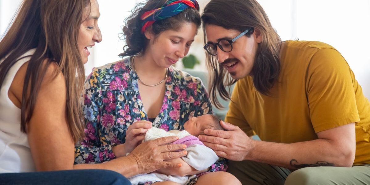 Ouders met pasgeboren baby ontvangen kraamvisite thuis