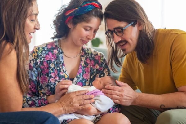 Ouders met pasgeboren baby ontvangen kraamvisite thuis