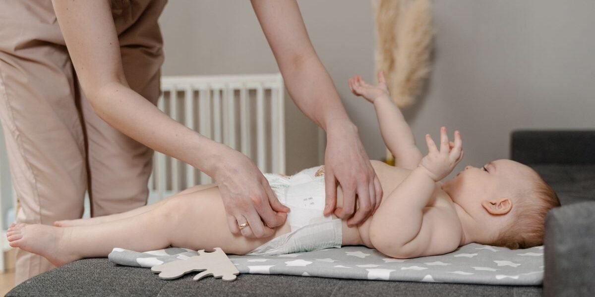 Ouder doet een luier om bij een baby op de commode