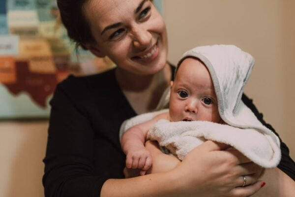 Moeder houdt pasgeboren baby in een warme handdoek thuis na een thuisbevalling