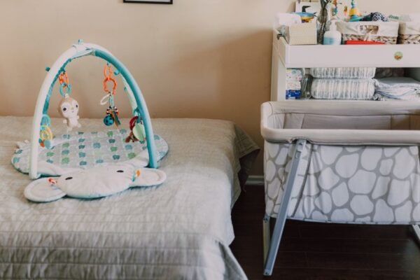 Mobiele verrijdbare wieg naast het ouderlijk bed in een lichte kamer
