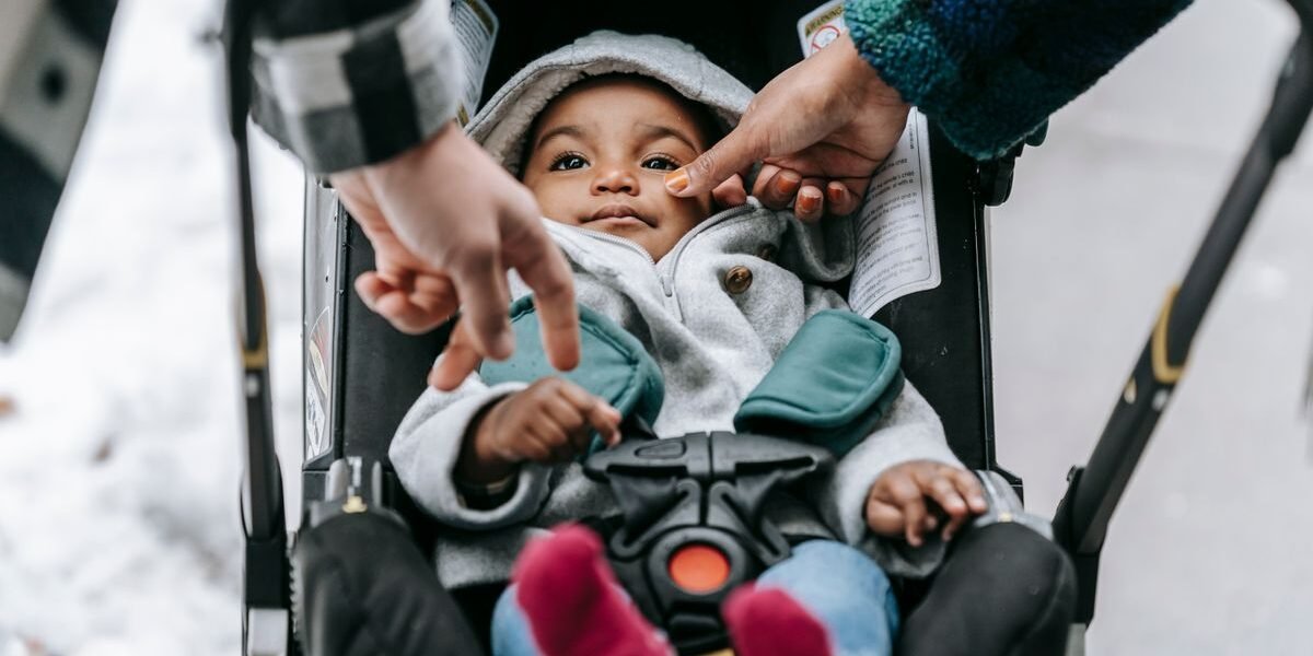 Warm ingeduffelde baby ligt in de kinderwagen op een koude winterdag