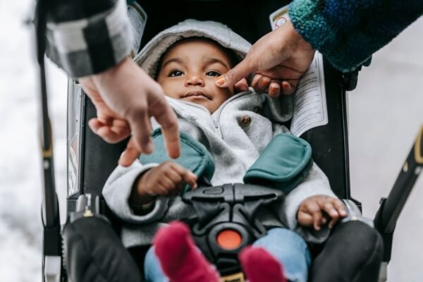 Warm ingeduffelde baby ligt in de kinderwagen op een koude winterdag