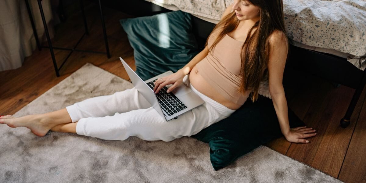 Zwanger koppel maakt geboortelijst aan op laptop rond week 20