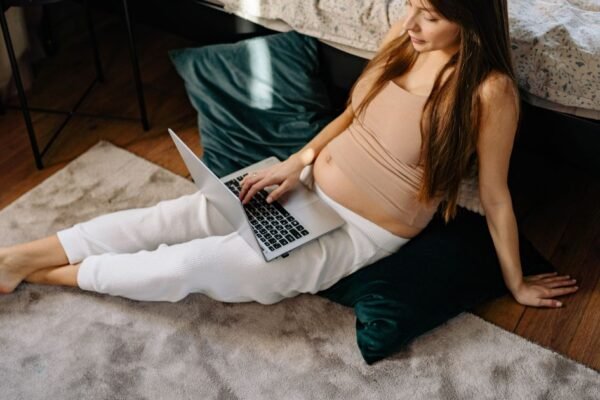 Zwanger koppel maakt geboortelijst aan op laptop rond week 20