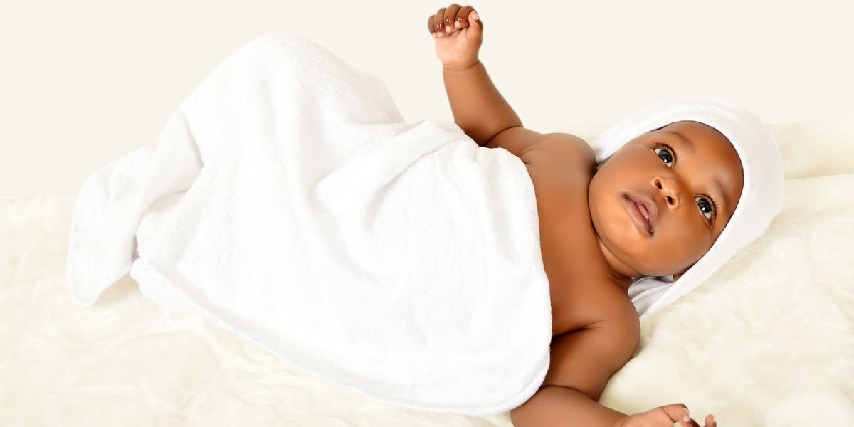 Pasgeboren baby wordt gewogen op een babyweegschaal