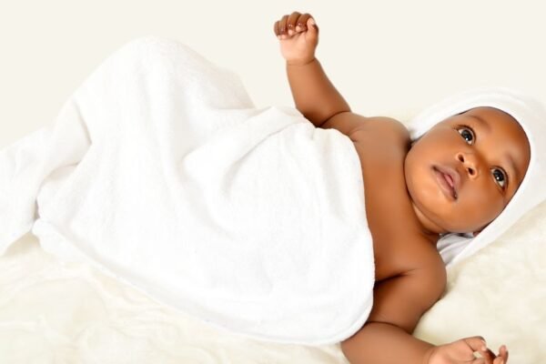 Pasgeboren baby wordt gewogen op een babyweegschaal