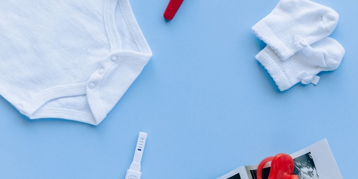 Baby musthaves op een commode: draagzak, slaapzak, luiers en babyfoon