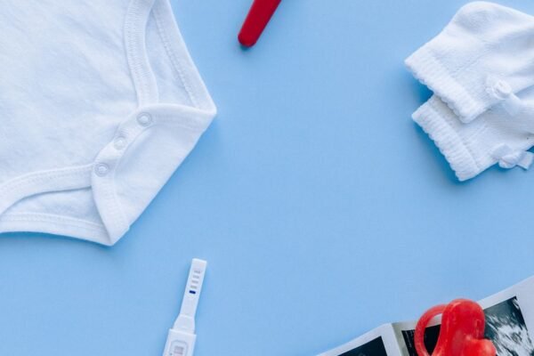 Baby musthaves op een commode: draagzak, slaapzak, luiers en babyfoon