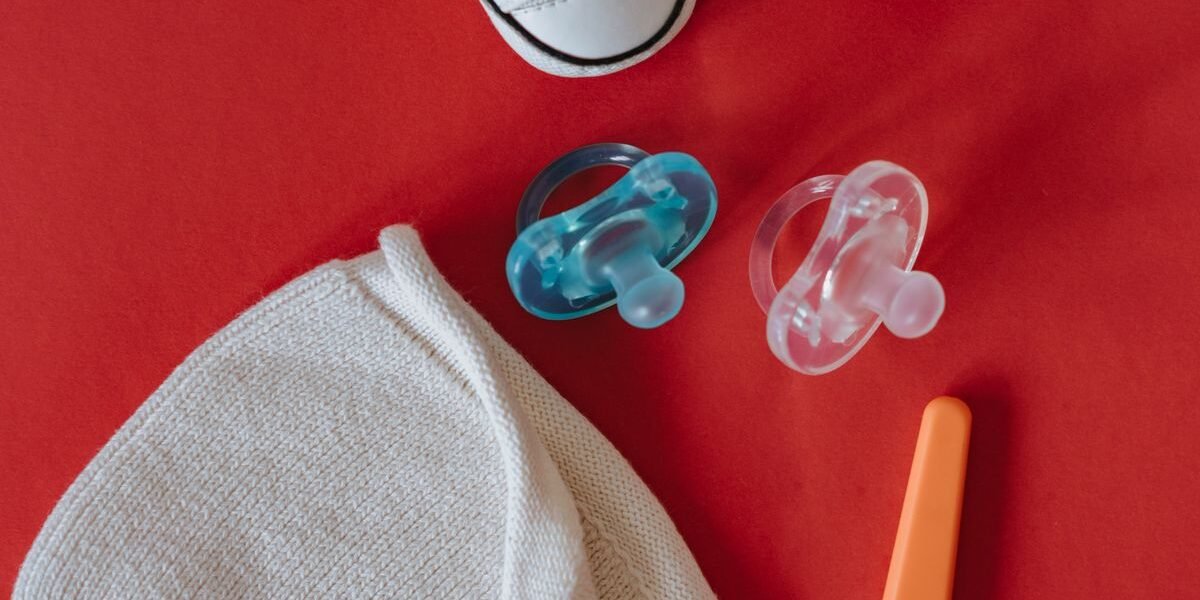 Baby uitzetlijst op papier naast rompers, luiers en een kruik