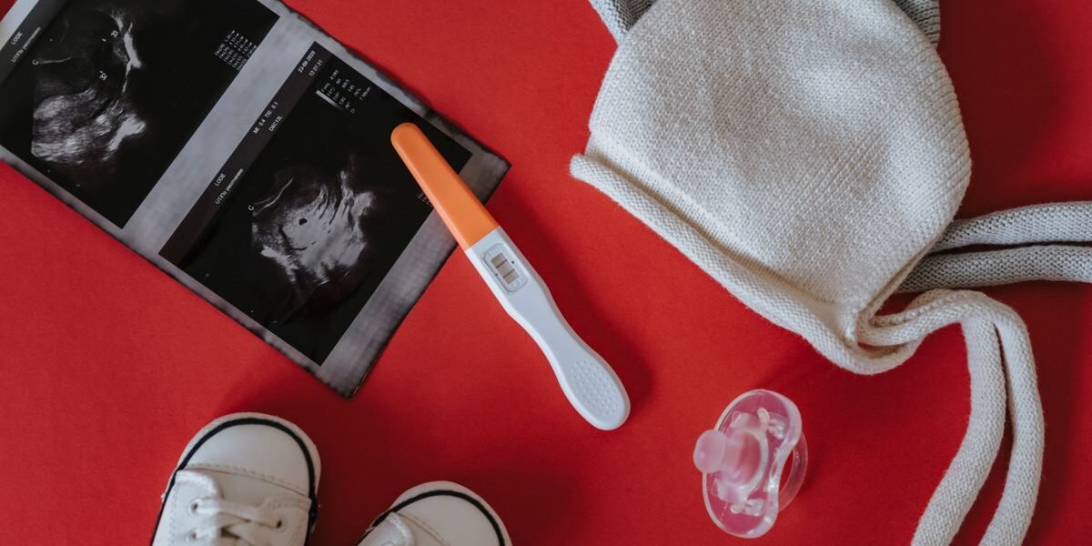 Minimale baby uitzet met rompers, luiers en slaapzak op een bed