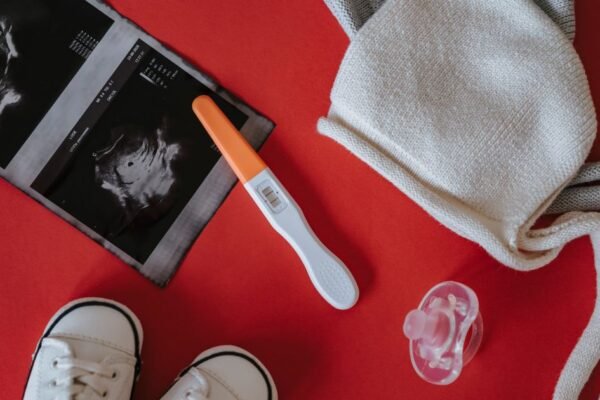 Minimale baby uitzet met rompers, luiers en slaapzak op een bed
