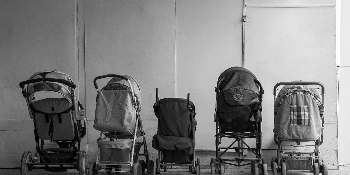 Ouders bekijken kinderwagens in showroom van babywinkel
