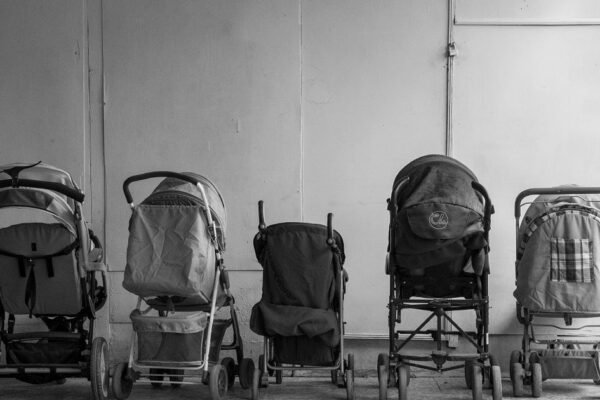 Ouders bekijken kinderwagens in showroom van babywinkel