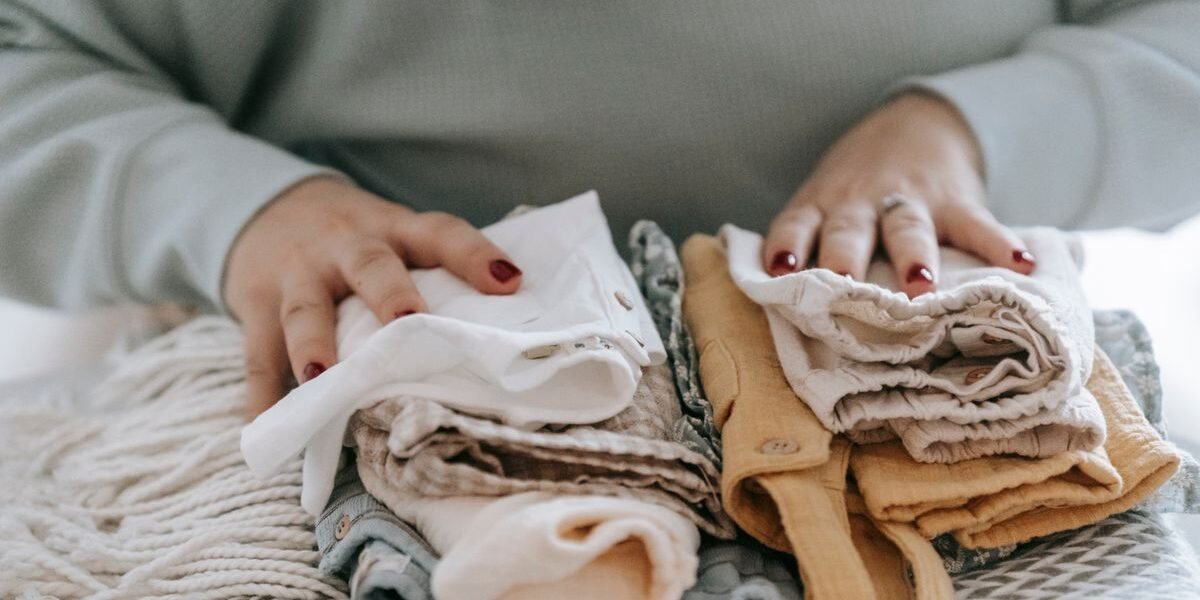 Gestapelde baby kleding in maat 56 en 62 voor de geboortelijst