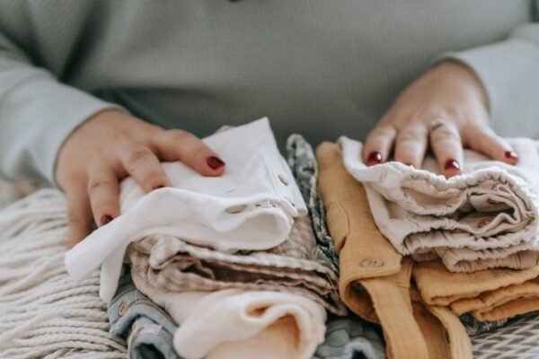 Gestapelde baby kleding in maat 56 en 62 voor de geboortelijst
