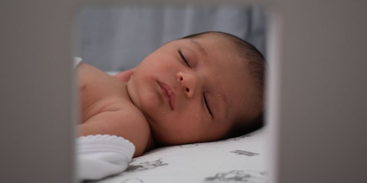Babyfoon met camera en app op smartphone naast babybed