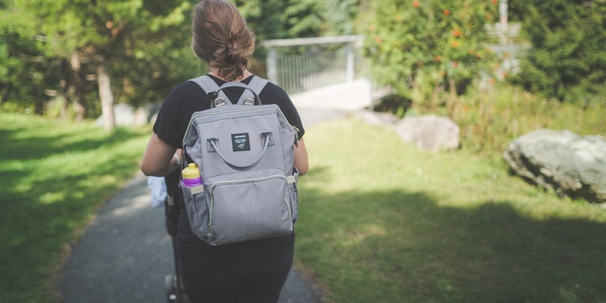 Beste luiertas rugzak hangt aan een wandelwagen met verschoningsmatje