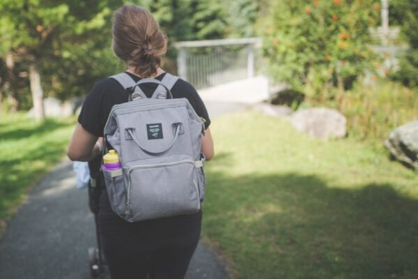 Beste luiertas rugzak hangt aan een wandelwagen met verschoningsmatje