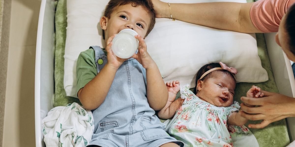 Ouder sorteert babyspullen uit een doos voor het tweede kindje