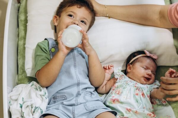 Ouder sorteert babyspullen uit een doos voor het tweede kindje