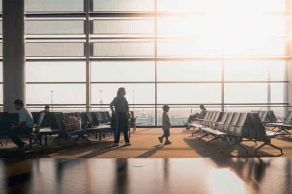 Ouders met baby in draagzak en lichte buggy op de luchthaven