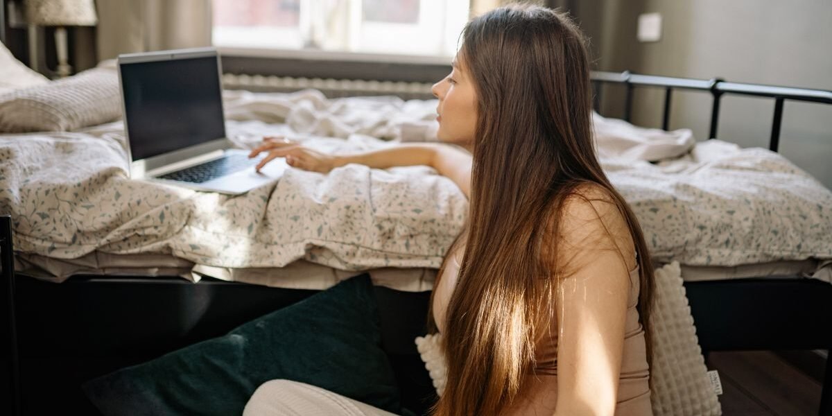 Zwangere vrouw maakt digitale geboortelijst op laptop aan keukentafel