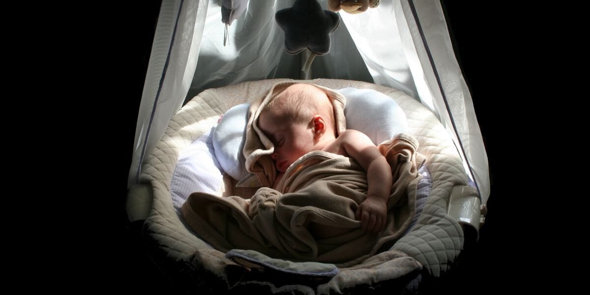 Pasgeboren baby slaapt in een wiegje tijdens de eerste nacht thuis