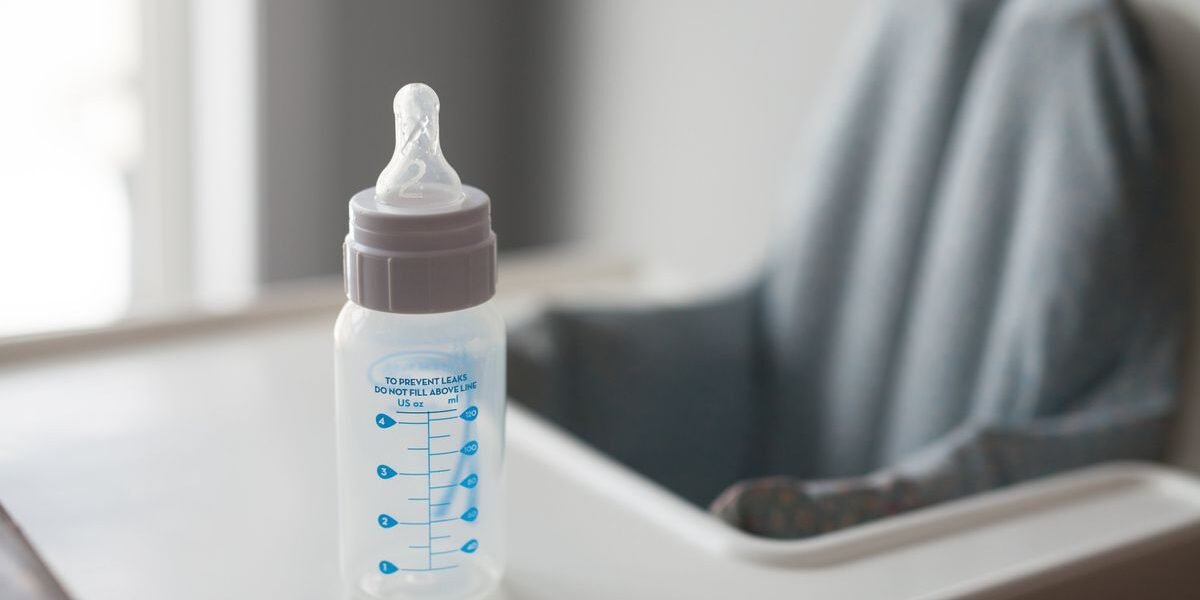 Babyflessen, spenen en sterilisator klaargezet voor flesvoeding op de geboortelijst