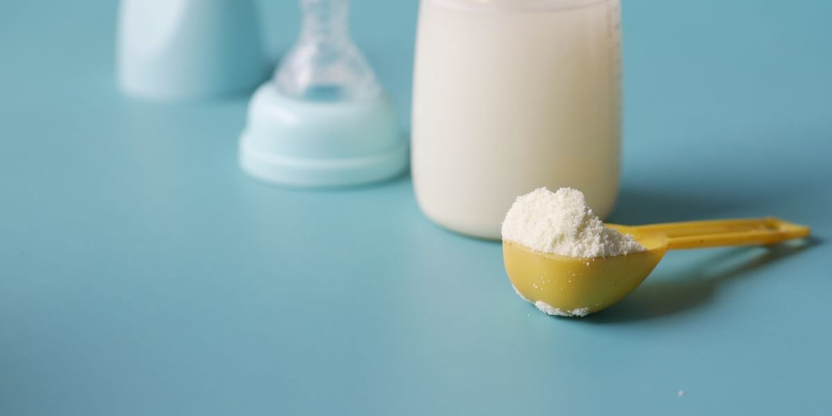 Verschillende flesvoeding merken in dozen naast een babyfles