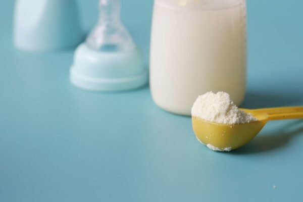 Verschillende flesvoeding merken in dozen naast een babyfles