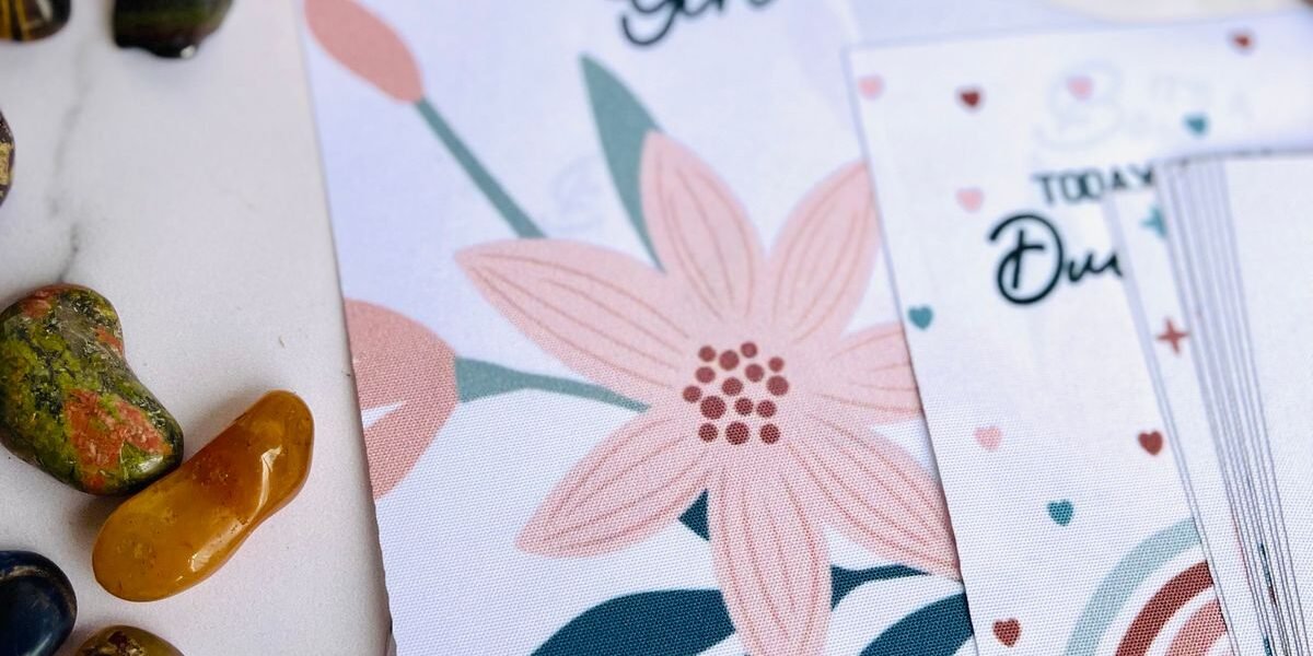 Geboortekaartje meisje met goudfolie en gedroogde bloemen op tafel