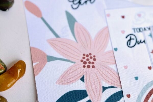 Geboortekaartje meisje met goudfolie en gedroogde bloemen op tafel