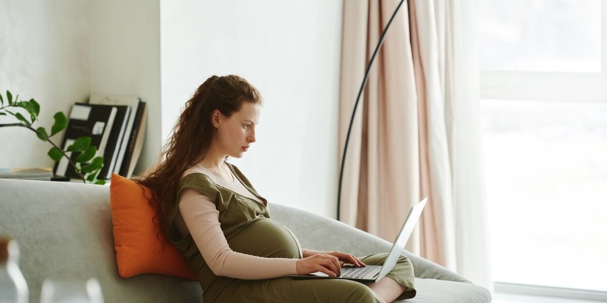 Zwangere vrouw maakt geboortelijst online op smartphone