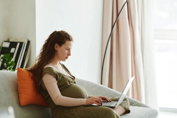 Zwangere vrouw maakt geboortelijst online op smartphone