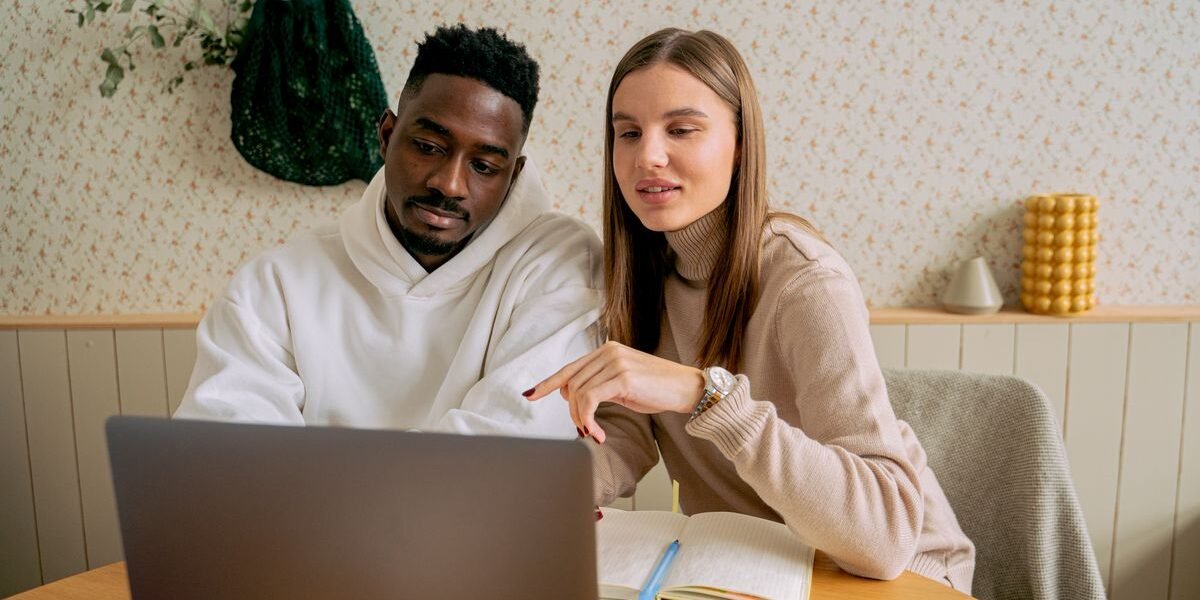 Koppel stelt samen een geboortelijst op met laptop en notities