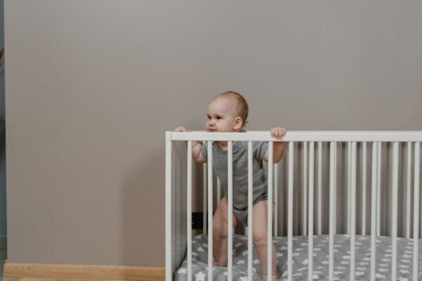 Eenvoudig wit ledikant in een rustige babykamer