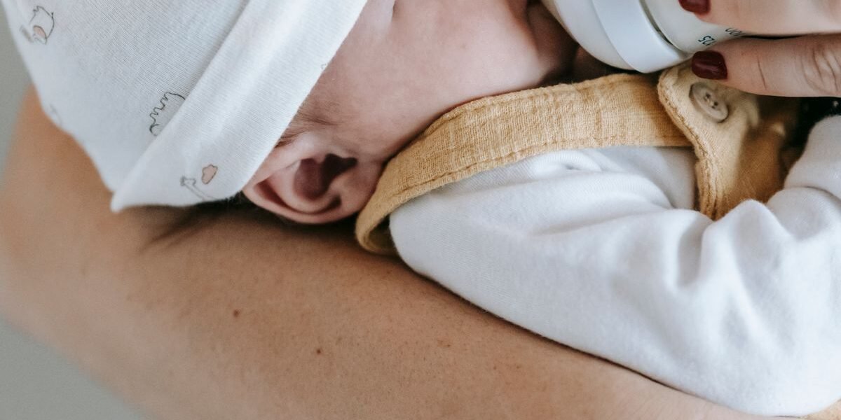 Ouder geeft flesvoeding aan baby van 2 weken op de arm