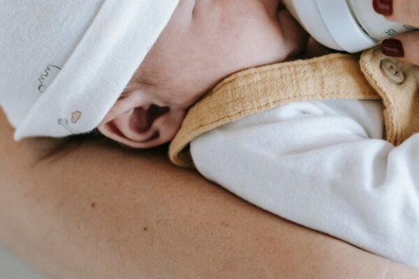 Ouder geeft flesvoeding aan baby van 2 weken op de arm